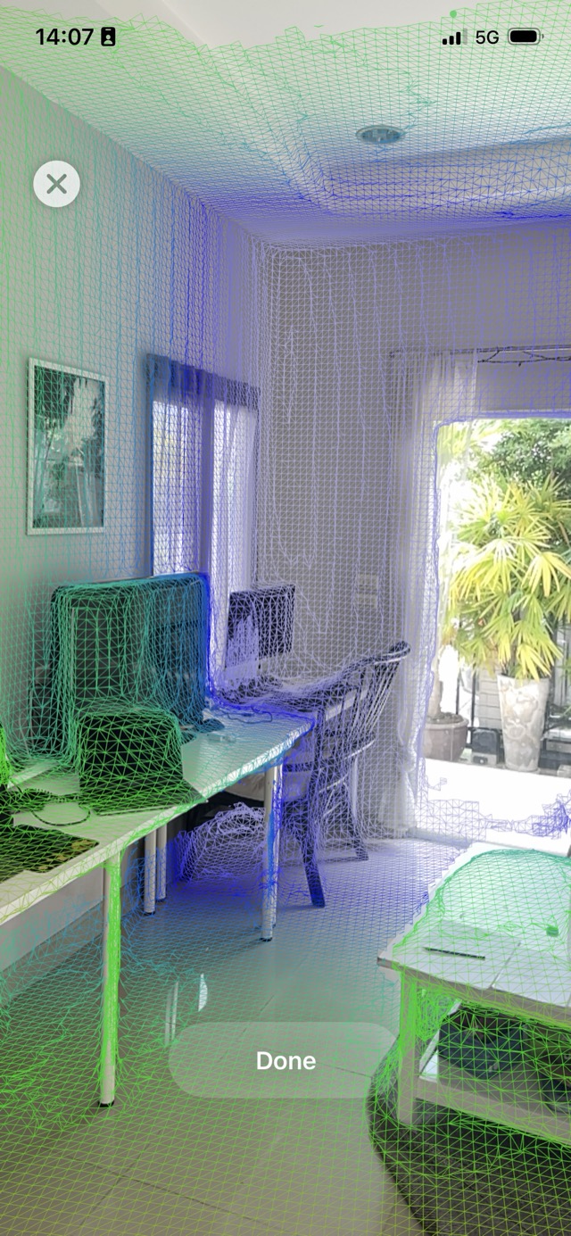 Live LiDAR scan in progress: the room is covered by a green-to-blue triangle mesh overlay